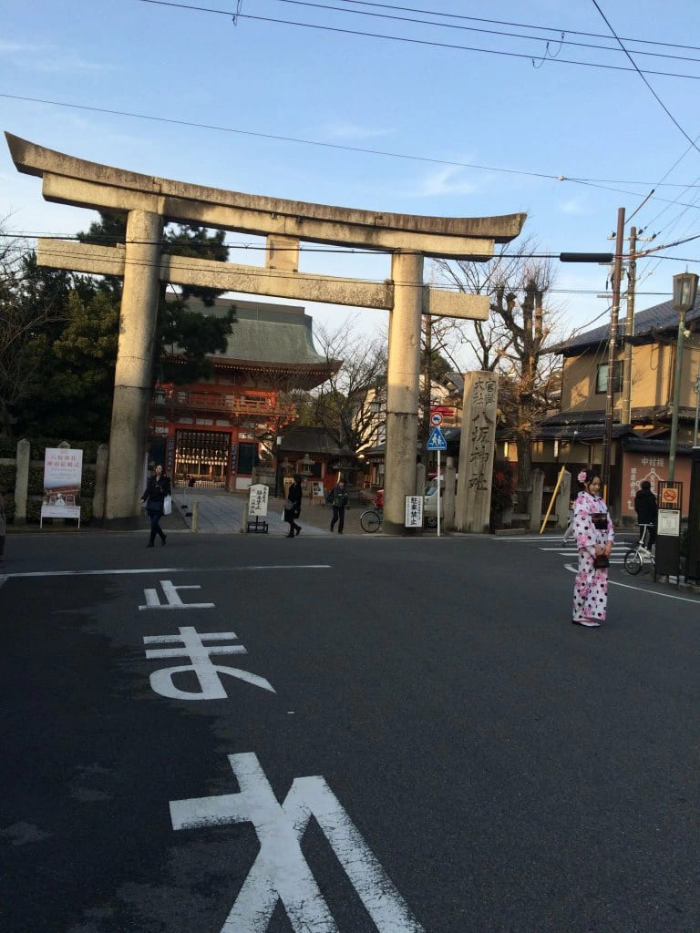 Гейша на фоне священных ворот Тории